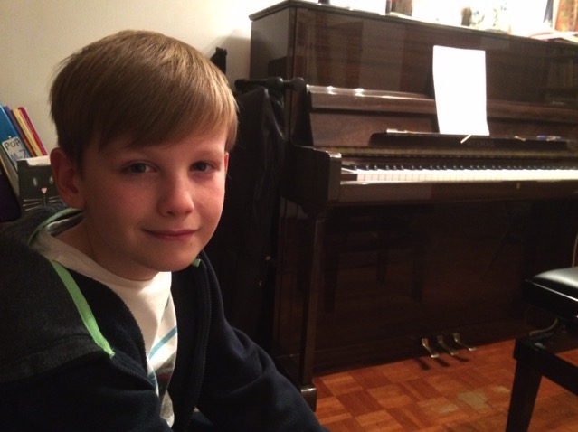 One of Helens kids next to a piano